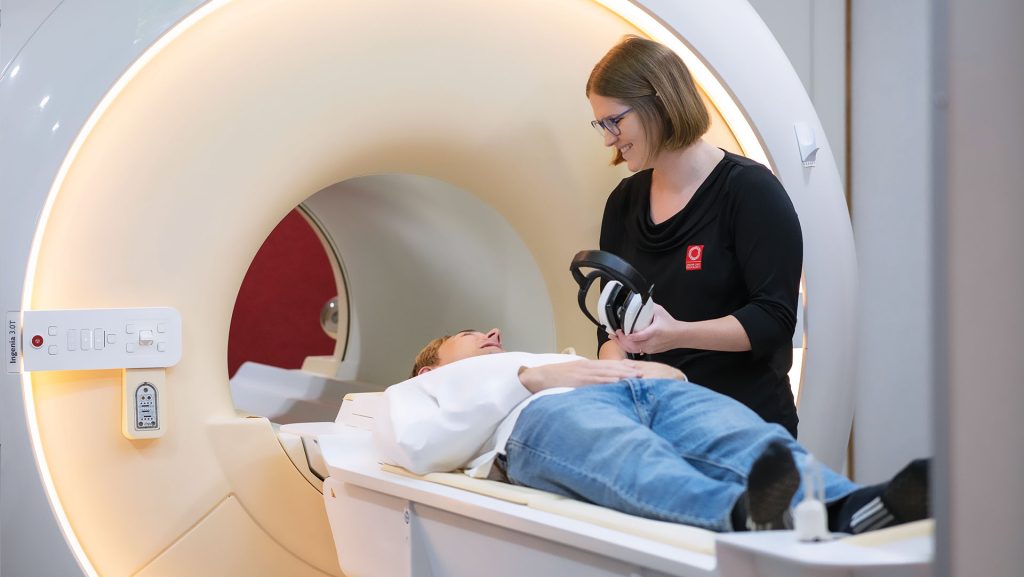 MRI technician caring for patient lying on MRI table as they enter the machine for MRI bulk billed