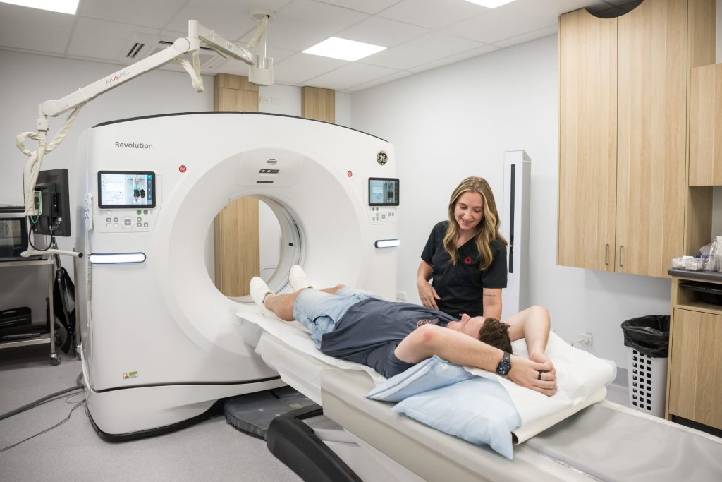 Radiographer speaks with patient as they're about to go into a CT scan at Imaging Queensland