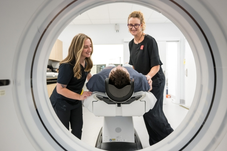Two CT Radiographers support patient entering CT scan at Imaging Queensland.
